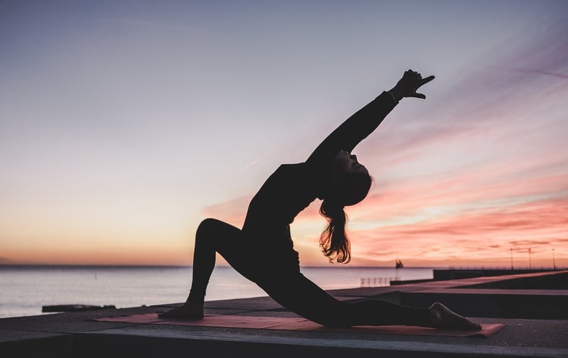 Woman practicing yoga at sunrise